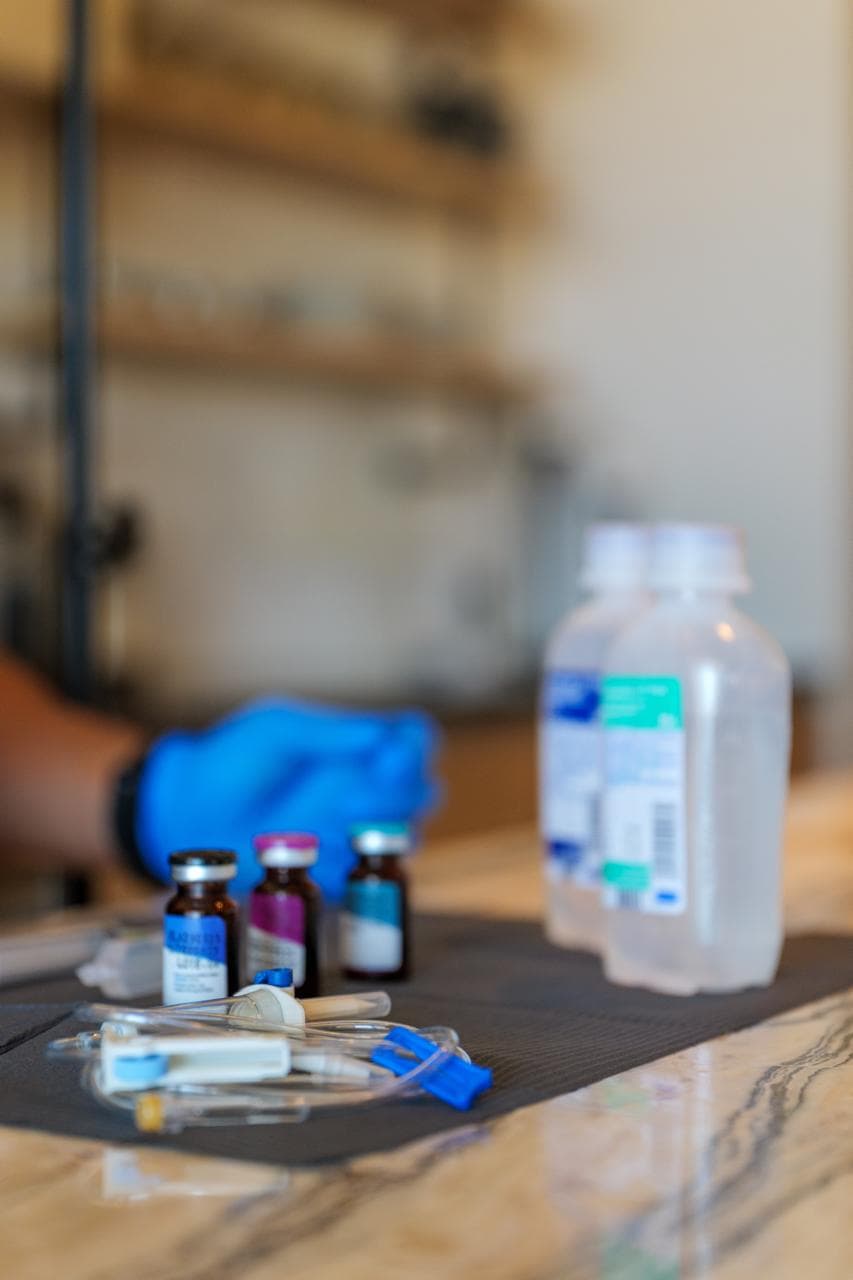 IV hydration supplies and medication vials laid out on a marble counter for a mobile hangover recovery session