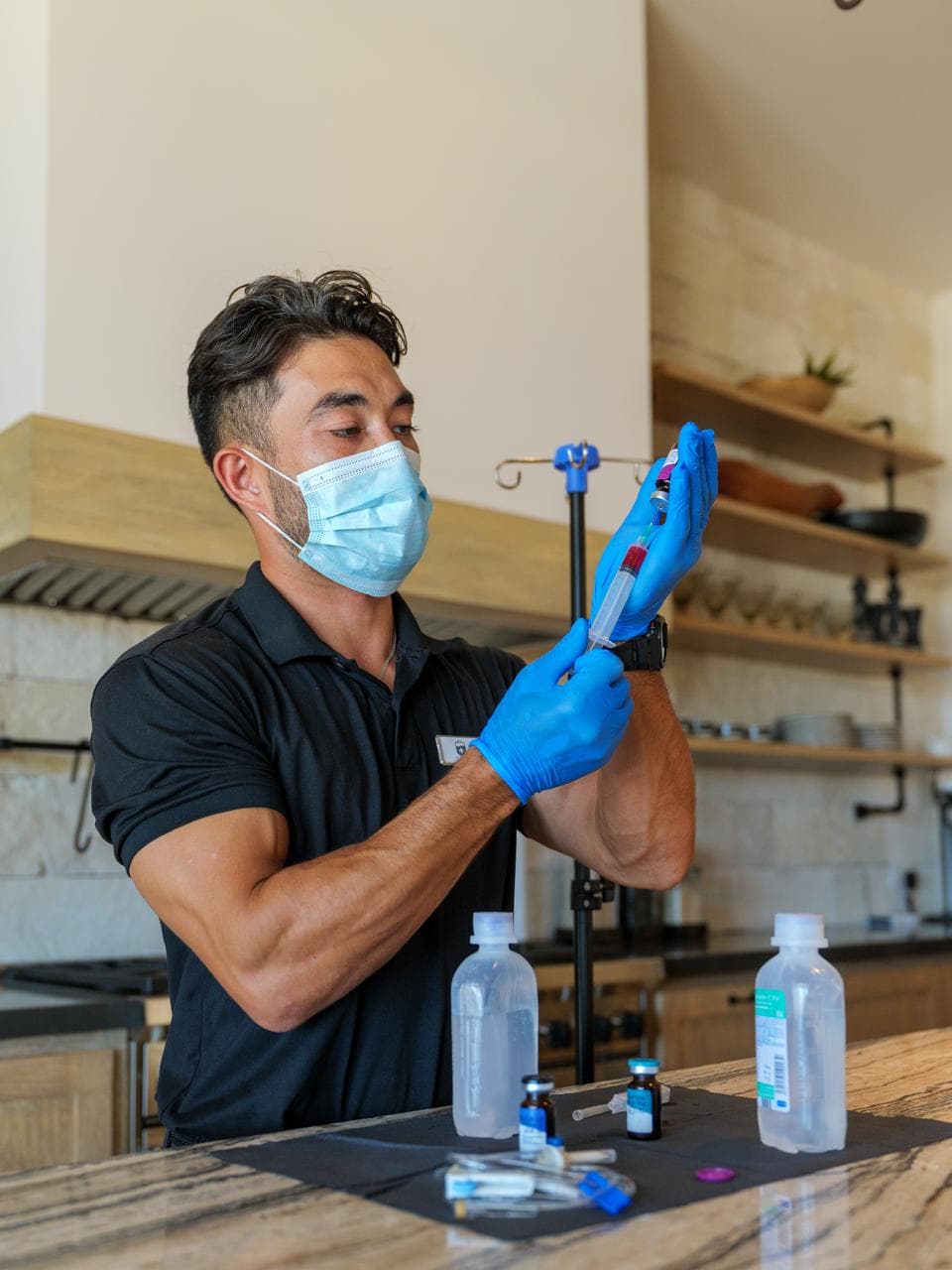 A Liquid Lounge nurse preparing a NAD+ IV infusion at a guest's villa in Los Cabos